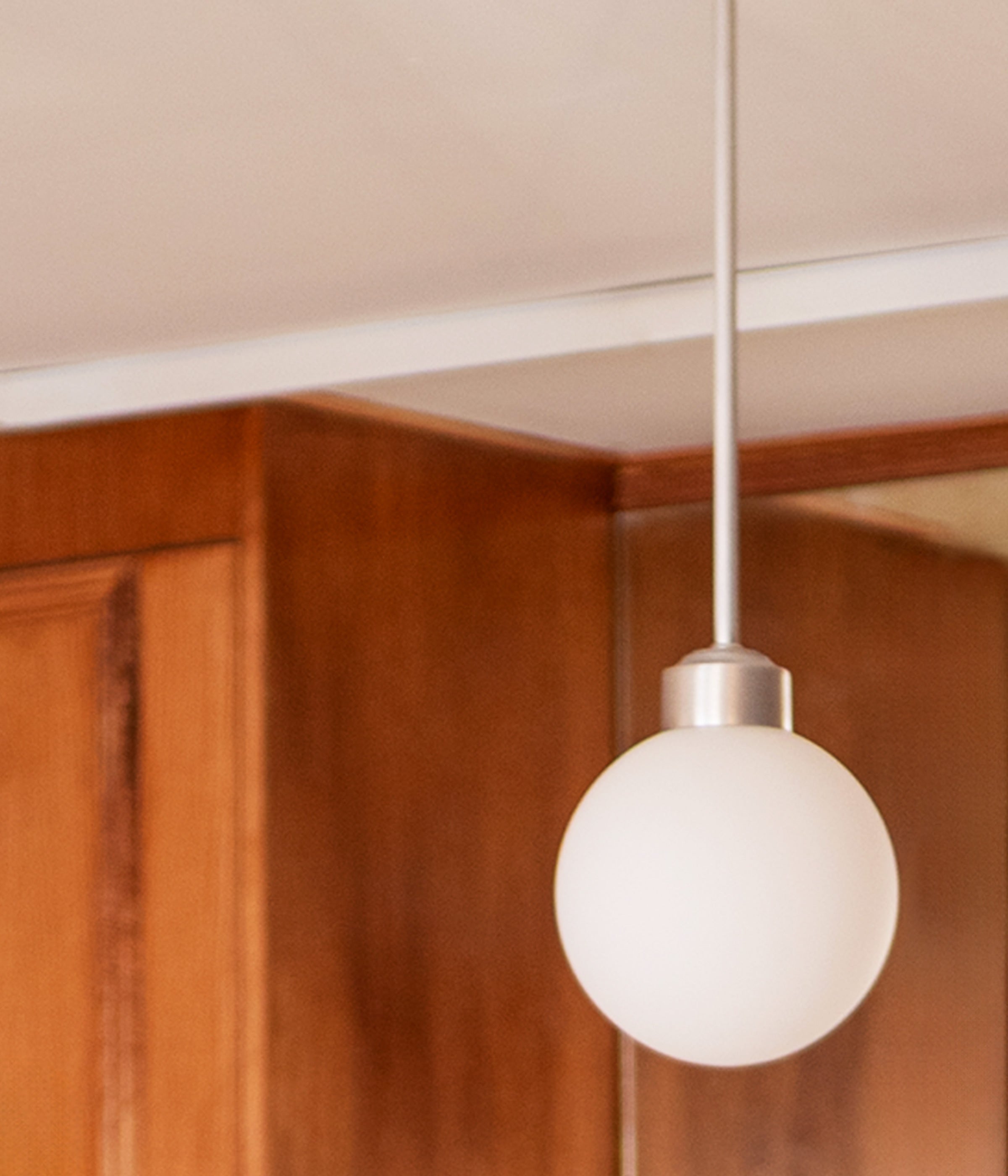 La Quincaillerie Moderne - Suspension "Bistro" en aluminium brossé avec un globe en opaline mate. À Paris, chez Comptoir de Madeleine