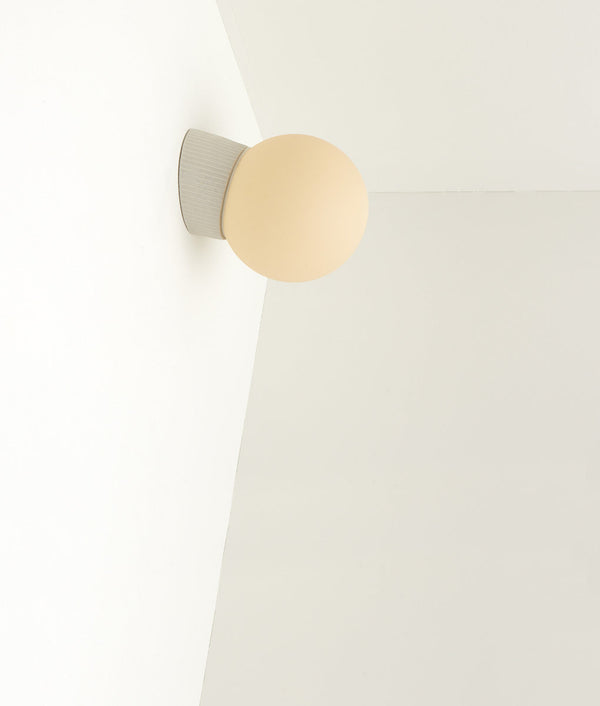 Applique inclinée "Grège" en porcelaine industrielle, verrerie boule mate crème, fines cannelures