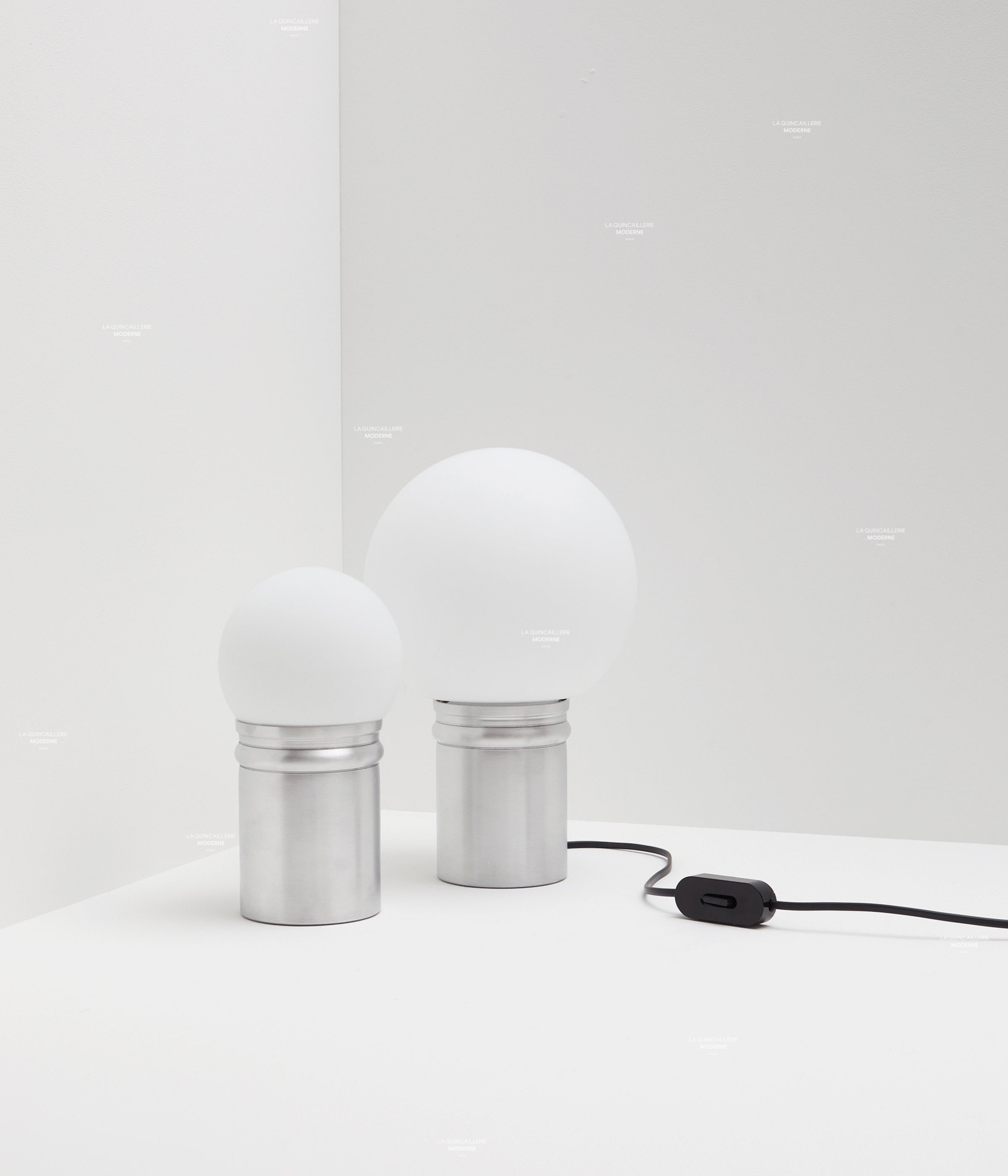 La Quincaillerie moderne - Collection de lampes de bureau "Odyssée" en aluminium brut et verre opalin. Plusieurs tailles de globes. Fabrication artisanale en Europe, assemblé à Paris. 