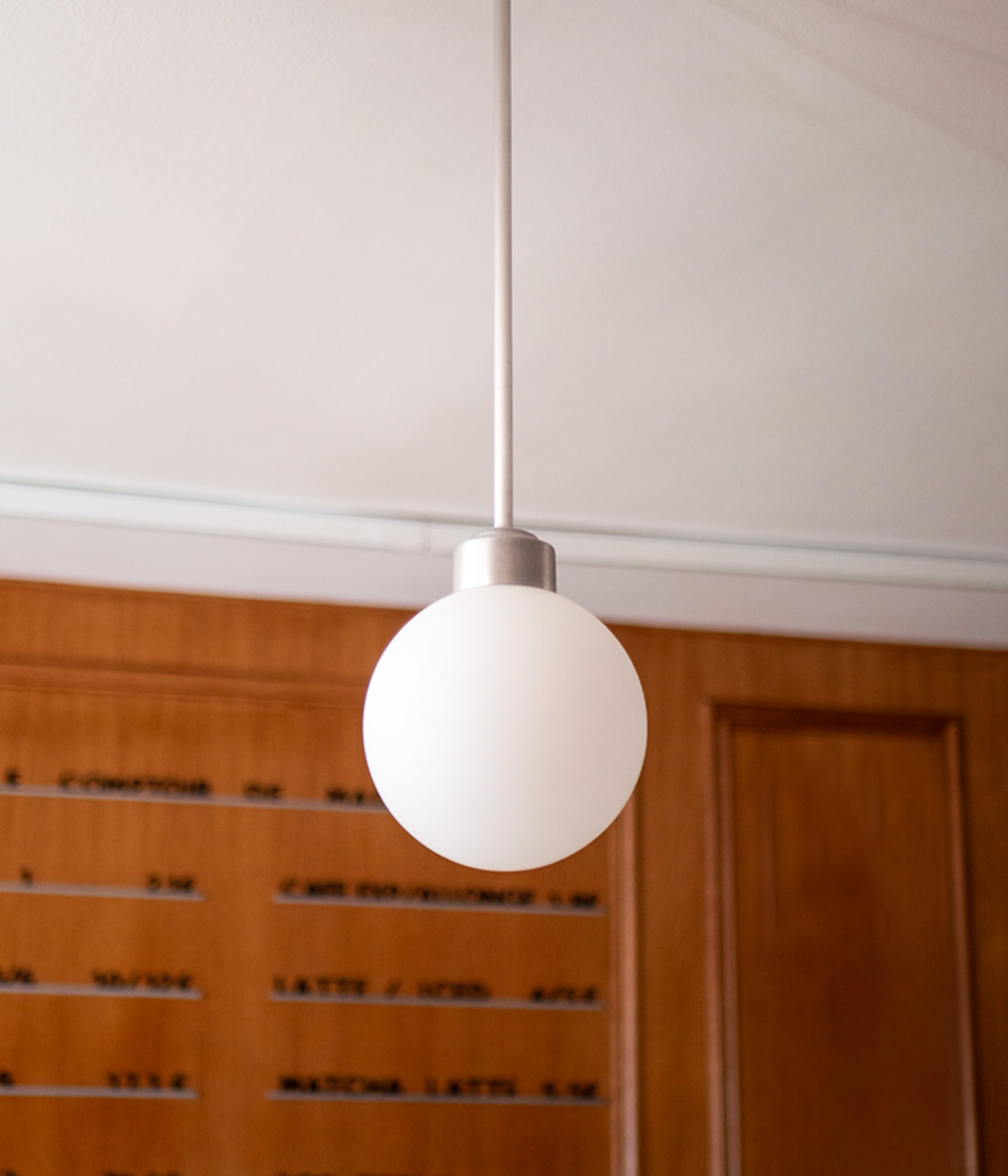 La Quincaillerie Moderne - Suspension "Bistro" en aluminium brossé avec un globe en opaline mate. À Paris, chez Comptoir de Madeleine