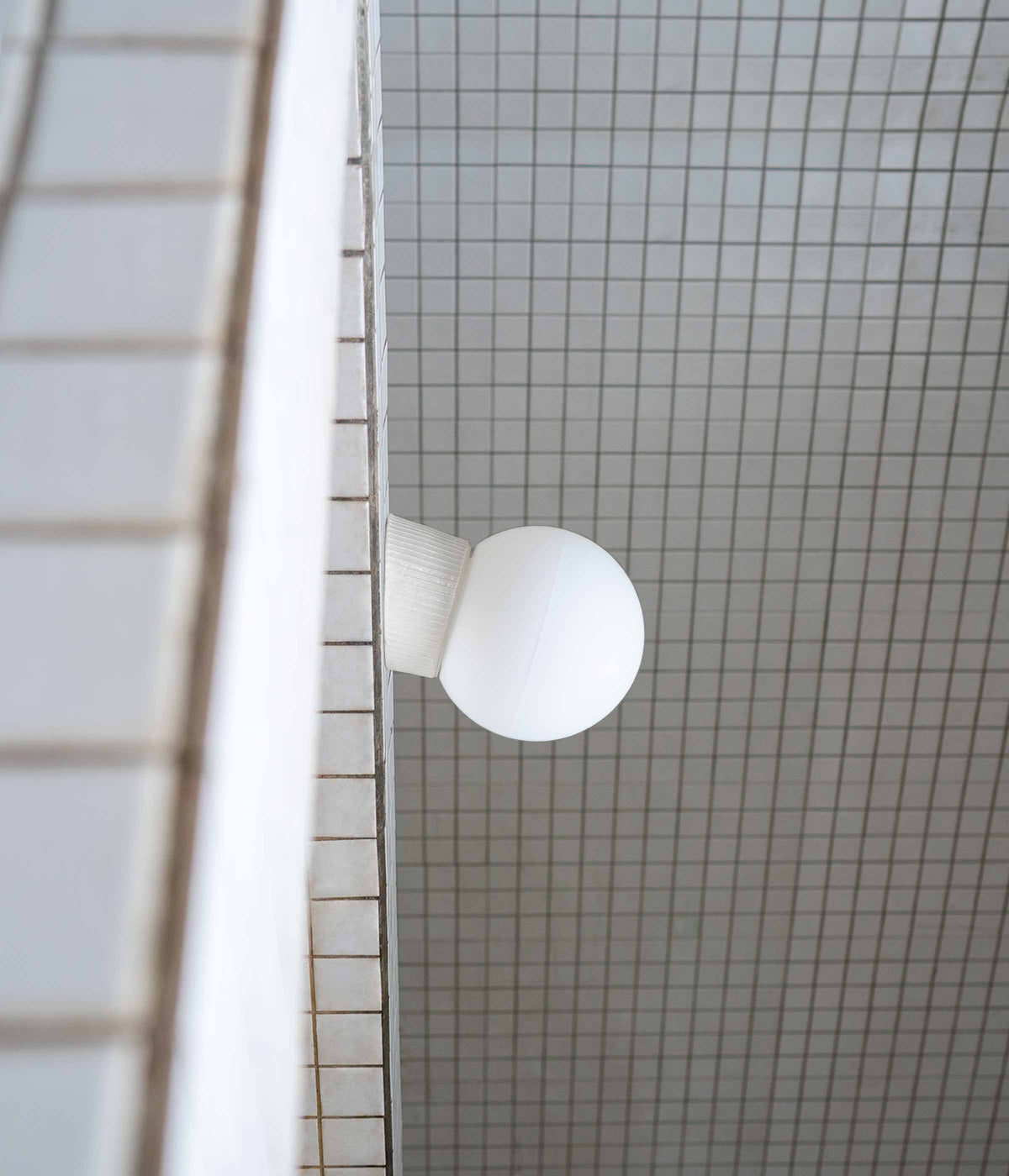 La Quincaillerie moderne - Applique inclinée "Grège" en porcelaine industrielle et verre opalin satiné. Socle à fines cannelures, petit globe, ø 15 cm. 