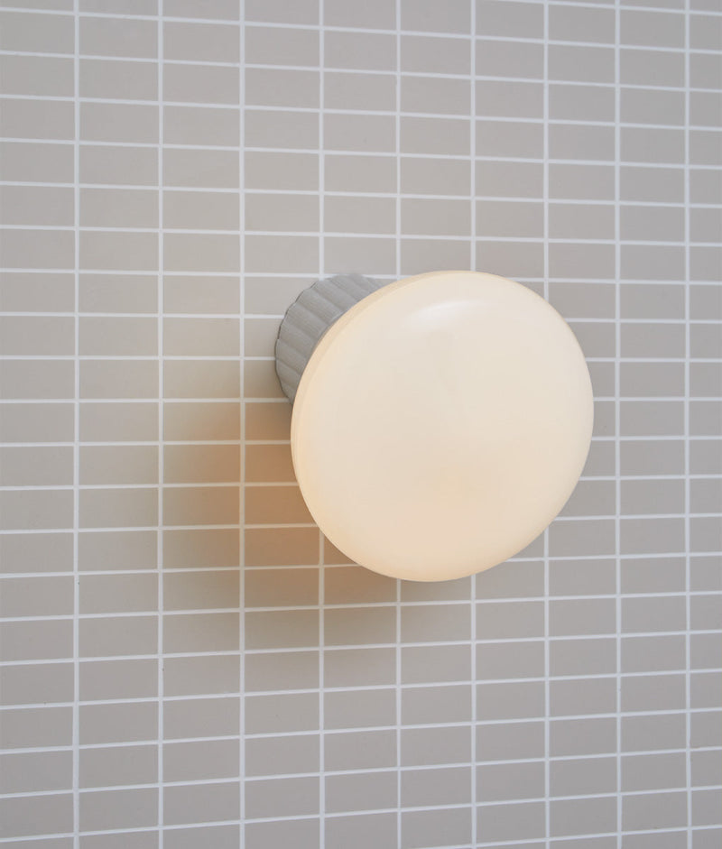 Applique inclinée en porcelaine industrielle "Grège", base à larges cannelures, verrerie "pointe" satinée, allumée