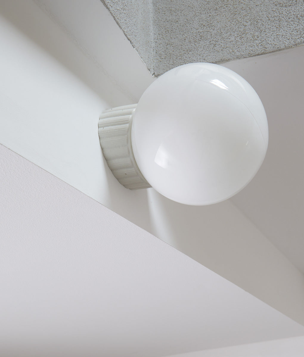 Applique inclinée "Grège", base à larges cannelures, verrerie boule satinée, dans l'escalier