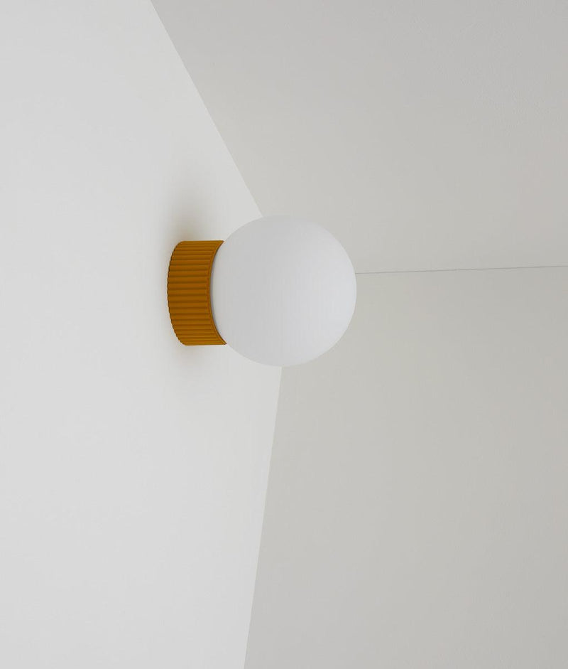 Applique "Colonnade", base à fines cannelures, verrerie boule mate, jaune safran